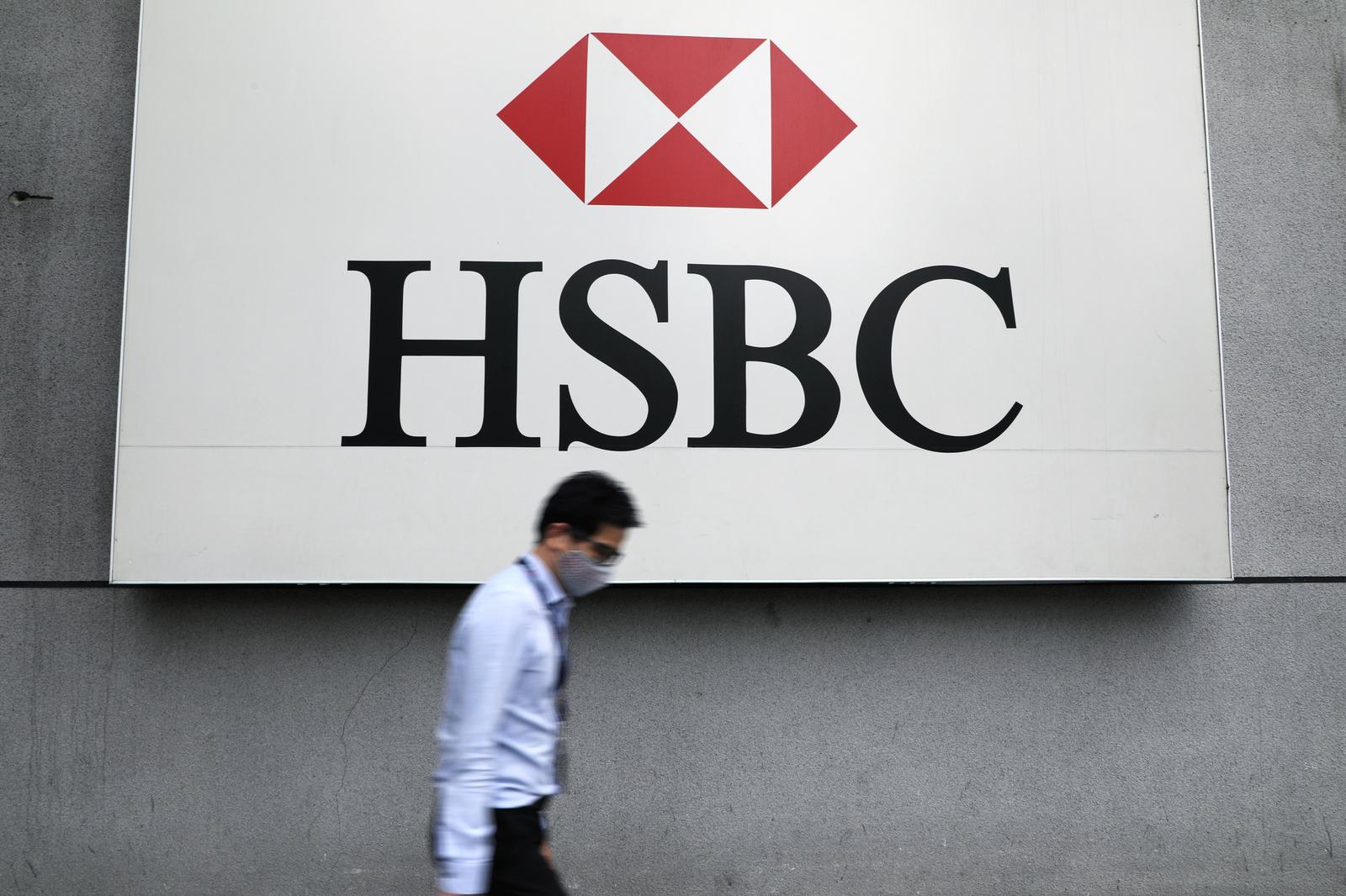 A man wearing a protective mask walks past a logo of HSBC at its headquarters, amid the coronavirus disease (COVID-19) outbreak in Kuala Lumpur, Malaysia September 9, 2020. REUTERS/Lim Huey Teng/File Photo